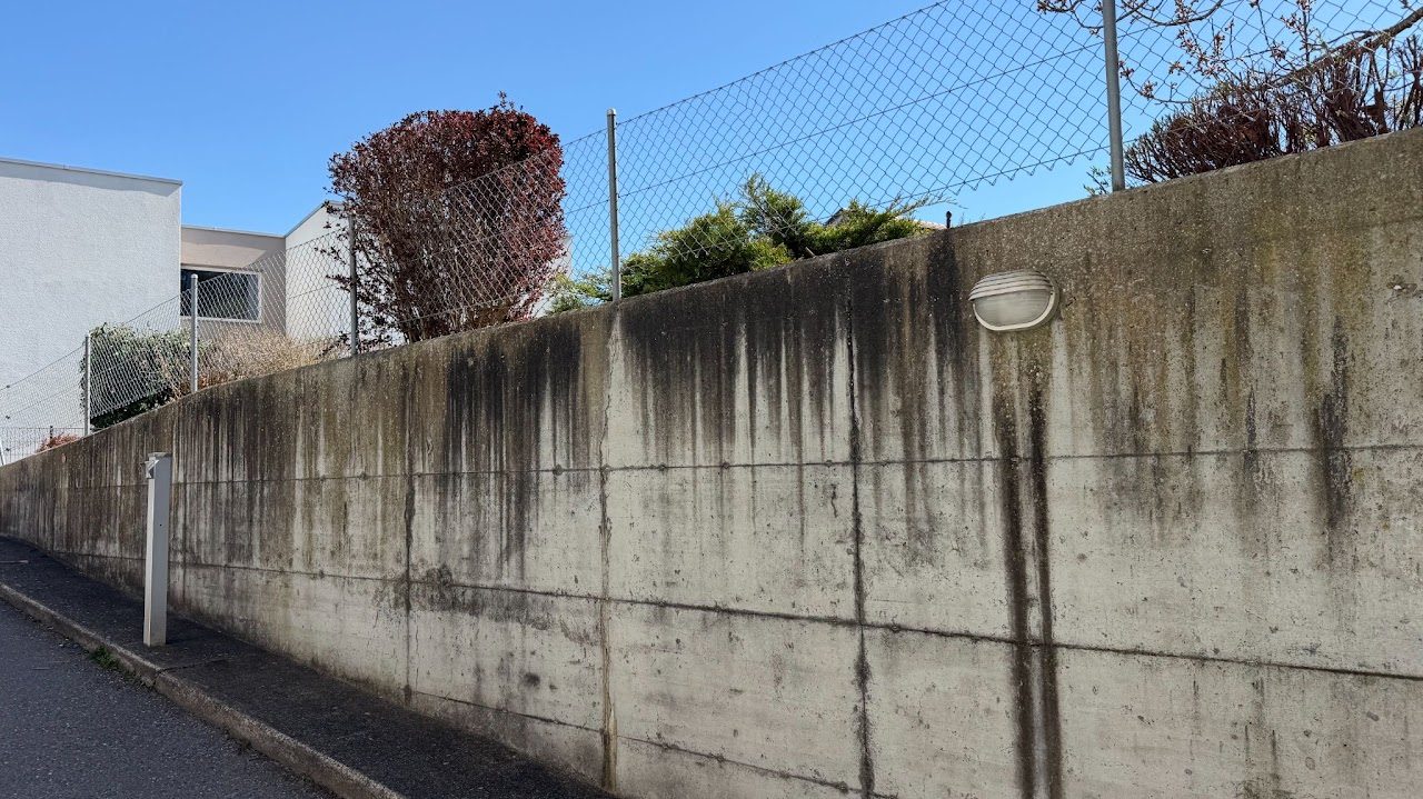 Avant nettoyage : mur en béton marqué par des traces noires